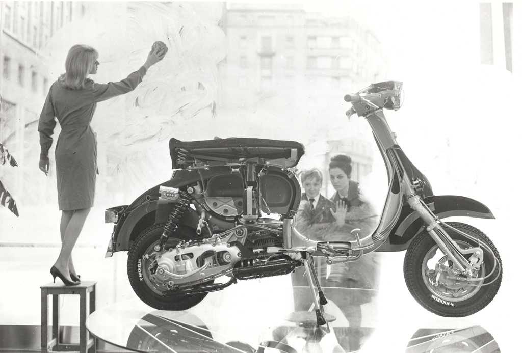 1960 Lambretta scooter in shop window with two persons looking