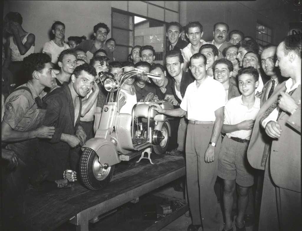 Gino Bartali and crowd watching Lambretta scooter